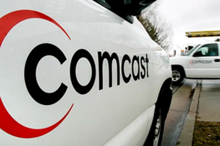 Two Comcast trucks in Salt Lake City last year. Yesterday, the Philadelphia-based company said it had agreed to spend $570 million to buy stakes in sports networks in California and New England.