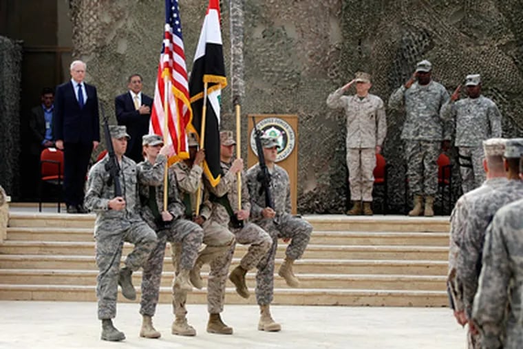 Military personnel march at a Baghdad ceremony marking the end of the U.S. mission. About 4,000 U.S. troops remained in Iraq as of Thursday, and the last will depart by the weekend. (Khalid Mohammed / Associated Press)