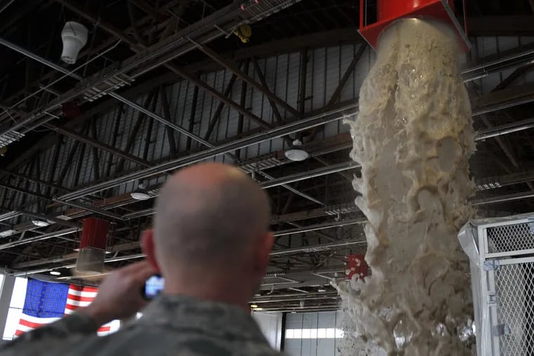 Foam pours out of a dispenser generator inside Hangar 211 Dec. 21, 2012, at Mountain Home Air Force Base, Idaho. Every two years, Airmen are required to test the fire suppression systems in order to protect people and equipment.