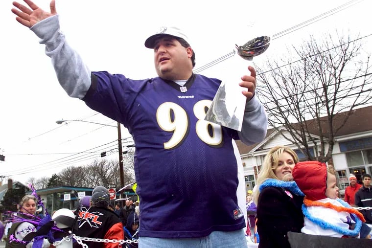 Tony Siragusa, defensive tackle for the Super Bowl-champion Baltimore Ravens, holds the Vince Lombardi trophy as he rides with his wife, Kathy, in a parade in his hometown of Kenilworth, N.J. in March 2001. Siragusa, the charismatic defensive tackle who helped lead a stout Baltimore defense to a Super Bowl title, has died at age 55. Siragusa's broadcast agent, Jim Ornstein, confirmed the death on Wednesday.