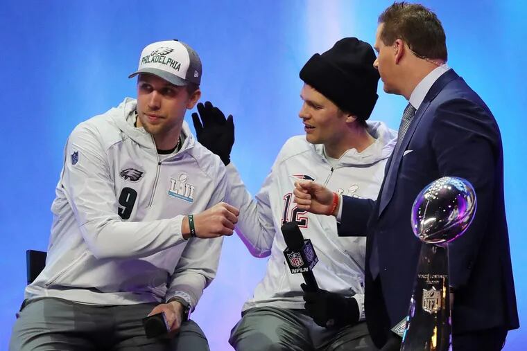 Nick Foles, left, and Tom Brady, center, after an interview at Super Bowl Media Night, at the Xcel Energy Center, in St. Paul, Minnesota, Monday, Jan. 29, 2018.