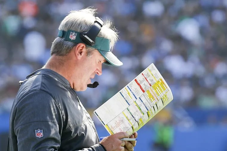 Eagles Head Coach Doug Pederson examines his play chart against the Los Angeles Chargers on Sunday, October 1, 2017 in Carson, CA. YONG KIM / Staff Photographer