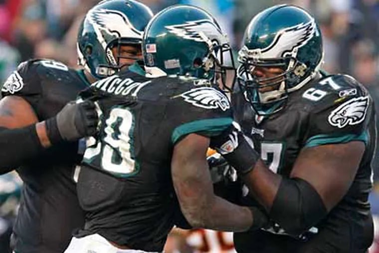 Nick Cole, left, and Jamaal Jackson pick up LeSean McCoy after his two
point conversion.  ( Ron Cortes / Staff Photographer )