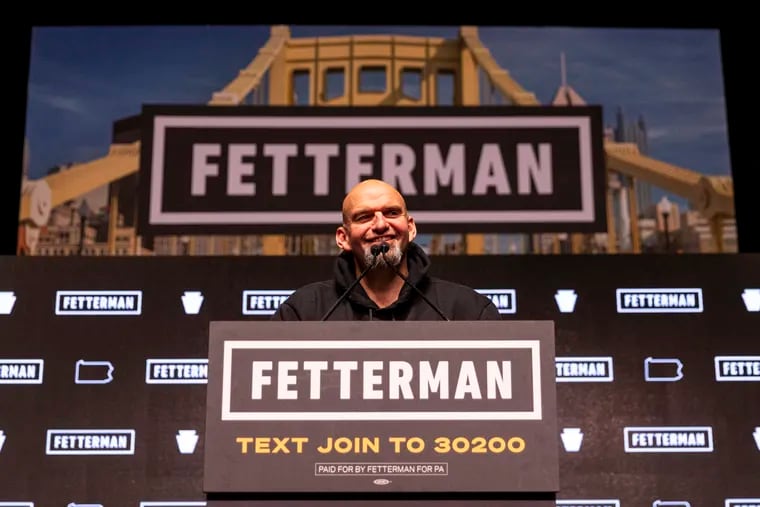 John Fetterman smiles behind the microphone as his supporters cheer him on Wednesday morning after he won the race for U.S. Senate in Pennsylvania.