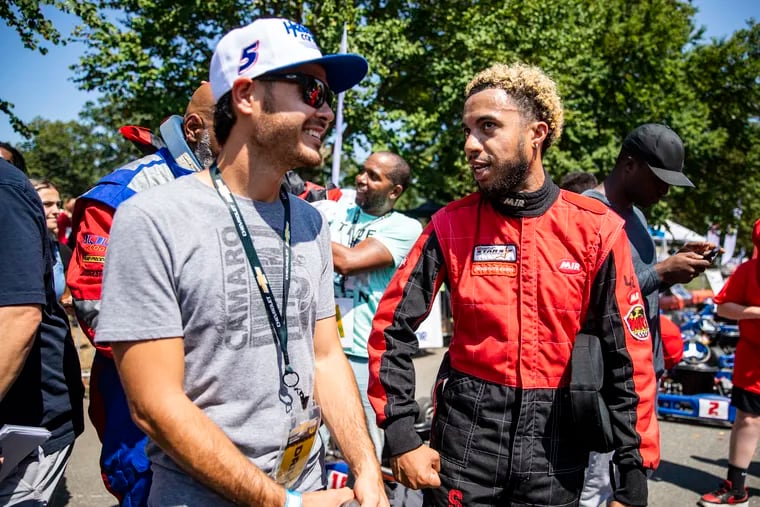 NASCAR Cup Series Champion Kyle Larson, left, shares a laugh with Jay Ortiz, 30, of Frankford, Pa., during the Urban Youth Racing School event on Friday in front of the Please Touch Museum in Philadelphia.