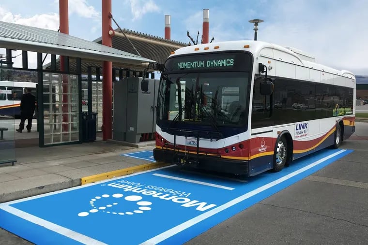 An electric bus in Wenatchee, Wash., equipped with a wireless charging system is positioned over a charging pad that can transfer energy through the air into a receiver mounted under the bus.