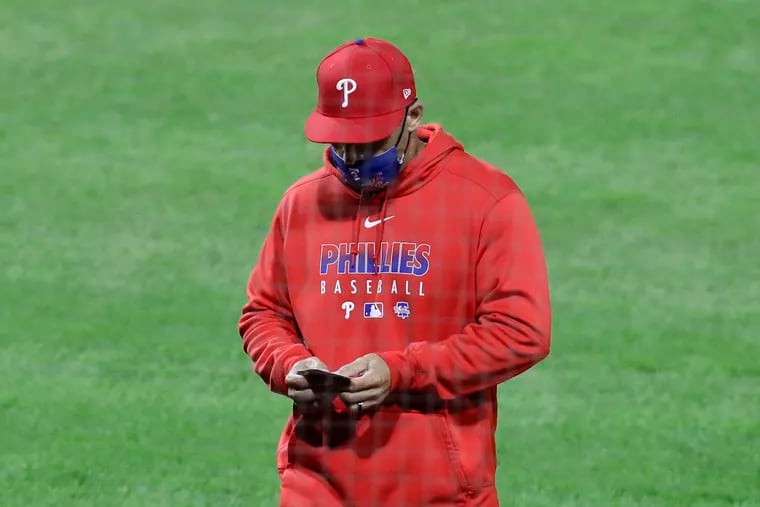 Phillies Manager Joe Girardi looks at his roster card against the New York Mets on Monday, April 5, 2021 in Philadelphia.