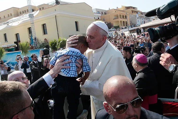 Pope Francis kisses a child in Lampedusa, an Italian island between Tunisia and Sicily where migrants wash ashore by the boatload. In his first trip outside Rome in 2013, he prayed for survivors of the crossing. (AP Photo/Gregorio Borgia)