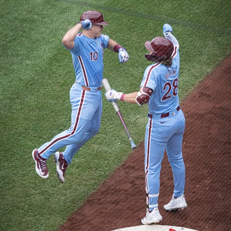 Philadelphia Phillies' J.T. Realmuto, right, and Alec Bohm celebrate after Realmuto's home run against Texas Rangers pitcher Andrew Heaney during the third inning of a baseball game, Thursday, May 23, 2024, in Philadelphia.