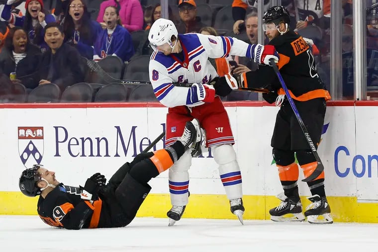 New York Rangers defenseman Jacob Trouba watches Flyers right wing Garnet Hathaway fall on the ice with left wing Nicolas Deslauriers in the first period on Nov. 24.