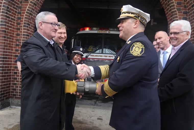 Mayor Jim Kenney and Fire Commisioner Adam Thiel recouple two hose lines to symbolize that the break in fire service has ended.