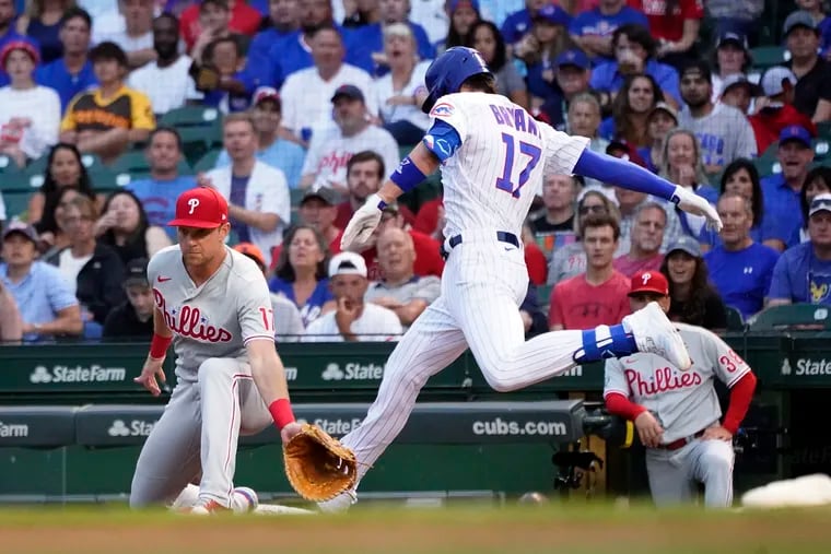 The Cubs' Kris Bryant (right) reaches first base before Rhys Hoskins can field the throw after an error by shortstop Didi Gregorius in the first inning on Wednesday night. The miscue led to four unearned runs for Chicago.
