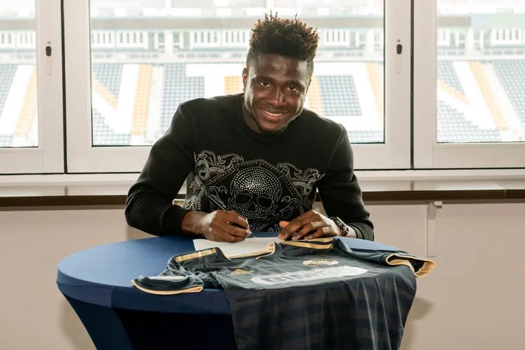 MIchee Ngalina smiles as he signs his first MLS contract with the Philadelphia Union.