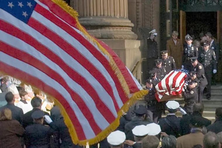 Officer John Pawlowski's flag-draped casket is carried out of the Cathedral Basilica SS Peter and Paul after the funeral Mass with police honor and color guards standing at attention. (Clem Murray / Staff Photographer)