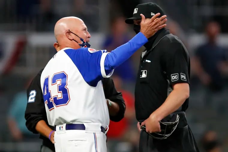 Braves manager Brian Snitker argues the outcome of a replay challenge that upheld a close call at home plate in the ninth inning of the Phillies' 7-6 victory Sunday night in Atlanta.