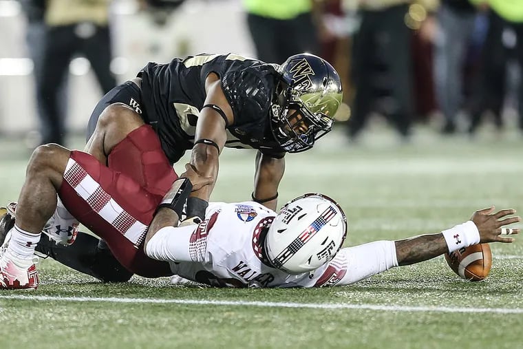 Temple' quarterback Phillip Walker is sacked by Wake Forest's Thomas Brown, causing him to fumble.