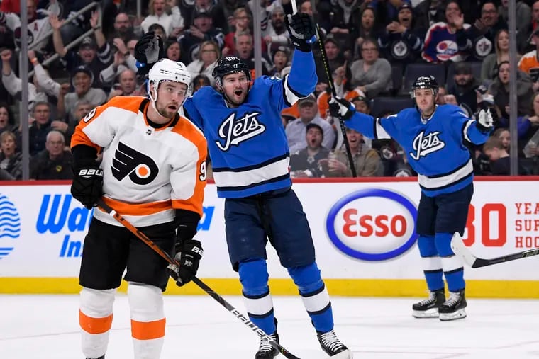 The Jets' Logan Shaw (38) celebrates scoring a goal during the second period as the  Flyers' Ivan Provorov (9) looks on.