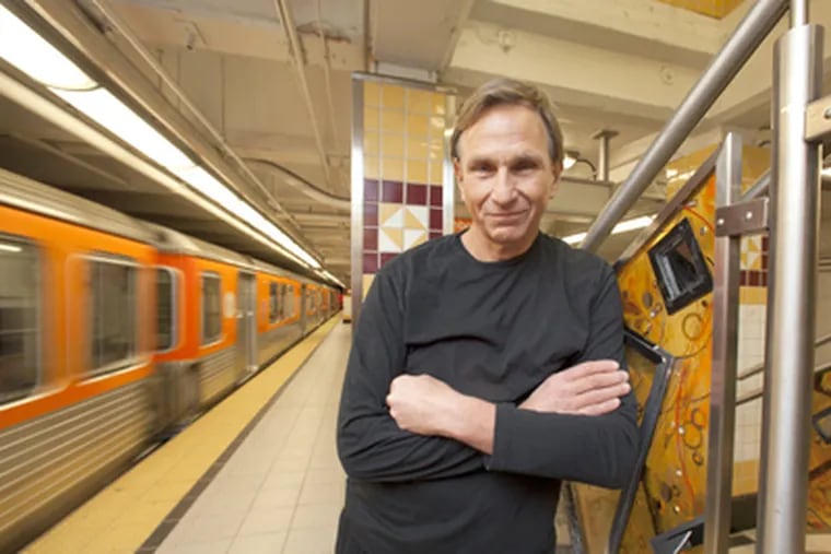 Artist Robert "Peanutbutter" Woodward at SEPTA's Girard Avenue station, where his translucent-resin panels are installed. (Ed Hille / Staff Photographer)