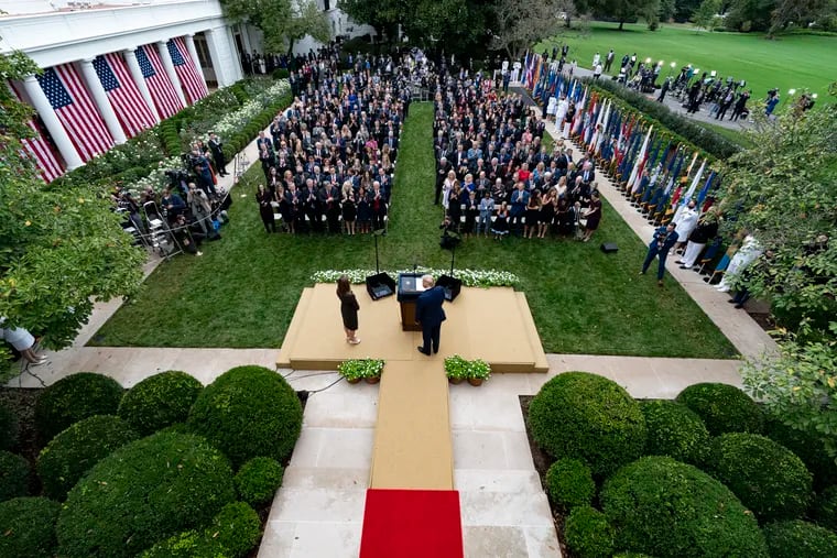 In this Sept. 26, 2020, photo, President Donald Trump (center) stands with Judge Amy Coney Barrett as they arrive for a news conference to announce Barrett as his nominee to the Supreme Court, in the Rose Garden at the White House in Washington. Former New Jersey Gov. Chris Christie watches from the fourth row from the front on the far right.