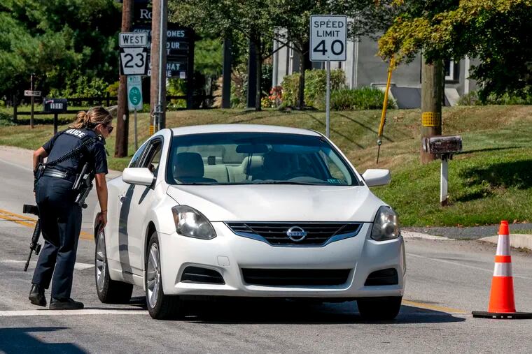 Police work a check-point for vehicles leaving the perimeter on Tuesday as the search for escaped convict Danelo Cavalcante continues.