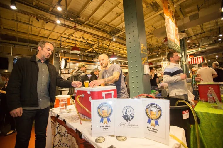 Andrew Foss (center), head brewer at St. Benjamin Brewing Company, pours beer after taking two first-place awards for Best New Beer and Best Lager at the Inquirer&#039;s Taste of the Brewvitational at Reading Terminal Market, May 11, 2017.