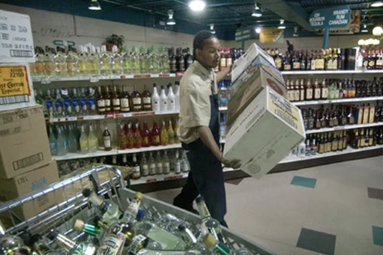 An employee stocks shelves at the Wine & Spirits store at Franklin Mills
Circle. (File Photo)