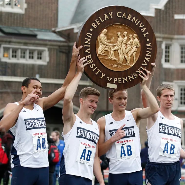 A Penn State relay team at the 2016 Penn Relays holds up the historic "wheel"  awarded to victors.