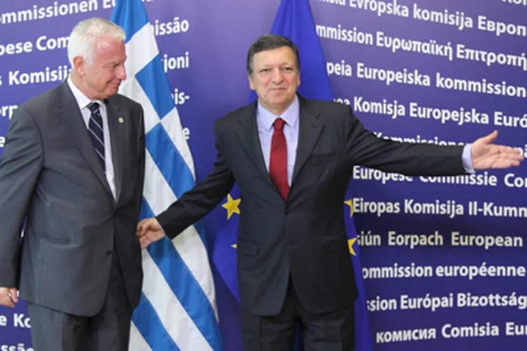 European Commission President José Manuel Barroso, right, ushers Greek Prime Minister Panagiotis Pikrammenos in Brussels. EU leaders gather at a summit to discuss ways to keep the debt crisis from spiraling out of control. YVES LOGGHE / AP
