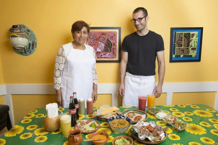 Cristina Martinez, left, and Ben Miller, right, photographed at South Philly Barbacoa, Friday, Sept. 16, 2016, in Philadelphia. On the table are two tacos, a bowl of consommé, and a half kilo of lamb. As well as fresh squeezed juices. ( JESSICA GRIFFIN / Staff Photographer)