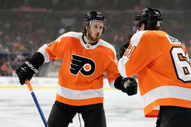 Flyers center Kevin Hayes talks to teammate Justin Braun before a faceoff in a game against Columbus in October. Hayes said Thursday that he misses being at the rink every day.