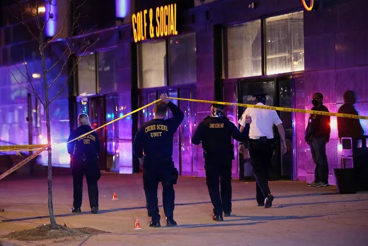 Police investigate the scene of a multiple shooting Friday night outside the Golf & Social bar, where seven people were reportedly shot around 8 p.m.
