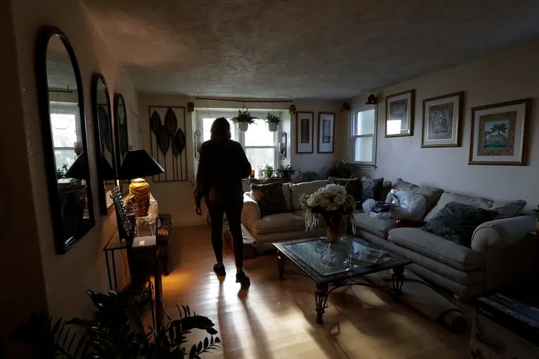 Theresa walks into her clean living room at her Northwest Philadelphia area home on Saturday.