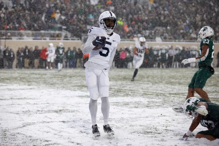 Penn State receiver Jahan Dotson (5) scores a touchdown against Michigan State's Xavier Henderson, bottom right, and Darius Snow (23) during the first half of an NCAA college football game, Saturday, Nov. 27, 2021, in East Lansing, Mich.