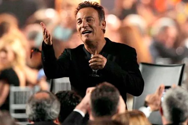 Honoree Bruce Springsteen gestures to attendees at the MusiCares Person of the Year tribute at the Los Angeles Convention Center on Friday Feb. 8, 2013, in Los Angeles. (Photo by Chris Pizzello/Invision/AP)