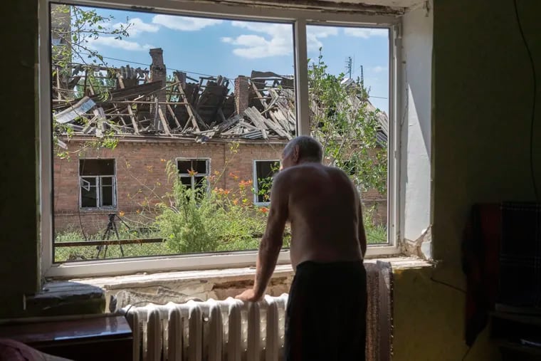Victor Rosenberg, 81, looks out of a broken window in his home destroyed by the Russian rocket attack in the city centre of Bakhmut, Donetsk region, Ukraine, Friday, July 1, 2022.