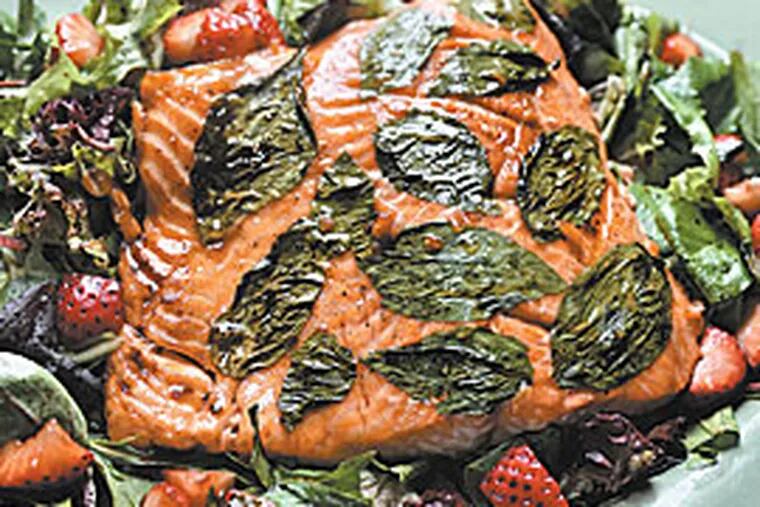 A surprise hit with the three households was honey-glazed salmon with fresh basil served over strawberries and salad. It was healthful, and the recipe came from an unlikely source. (Clem Murray / Inquirer)