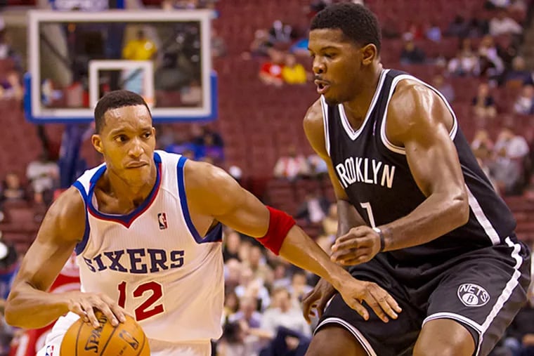 The 76ers' Evan Turner drives to the basket with the Nets' Joe Johnson defending him. (Chris Szagola/AP)