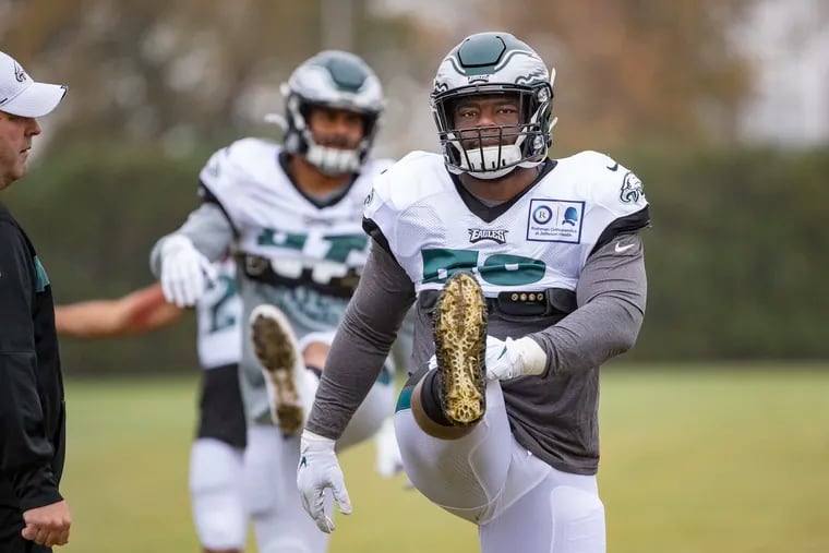 Newly aquired defensive end Genard Avery, right, participates in warms ups at Eagles practice on Wednesday.