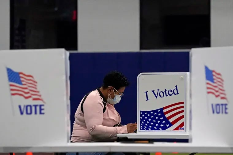 A woman votes at the MLB Urban Youth Academy in Kansas City, Mo. U.S. voters went to the polls starkly divided on how they see President Donald Trump’s response to the coronavirus pandemic, with a surprising twist. In places where the virus is most rampant now, Trump enjoyed enormous support.