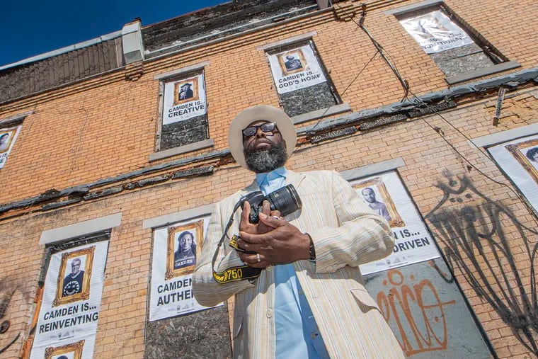 Erik James Montgomery in front of the portraits he is posting as part of a pop-up art installation naned 'Camden is Bright Not Blight.' Thirteen images of city residents and stakeholders have been installed on a trio of abandoned rowhouses along Mount Ephraim Avenue near downtown.