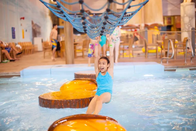 A girl plays in a "Big Foot Pass" activity pool at a Great Wolf Lodge.