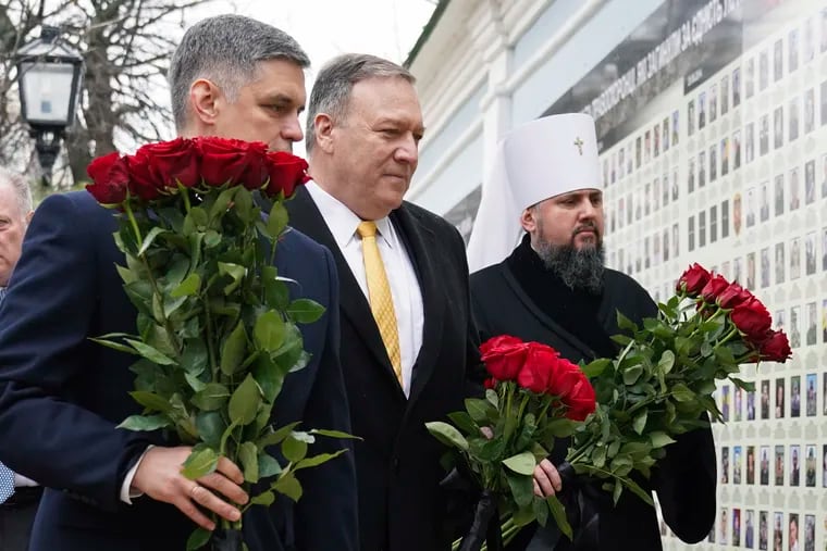 U.S. Secretary of State Mike Pompeo, center, Ukrainian Foreign Minister Vadym Prystaiko, left, and Metropolitan Epifaniy, head of the Orthodox Church of Ukraine, take part in a ceremony at the memorial to Ukrainian soldiers, who were killed in a recent conflict in the country's eastern regions, in Kyiv, Ukraine, Friday Jan. 31, 2020.