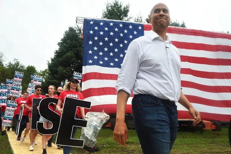 Sen. Cory Booker (D., N.J.) walks to the stage at the Polk County Steak Fry, a huge gathering of Democrats in Des Moines, Iowa, on Sept. 21. His campaign said Monday he hit a self-imposed fund-raising goal that will allow him to stay in the race.