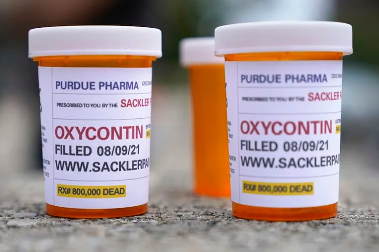 Fake pill bottles with messages about OxyContin maker Purdue Pharma displayed during a protest outside the courthouse where the bankruptcy of the company was taking place in White Plains, N.Y., on Aug. 9, 2021.