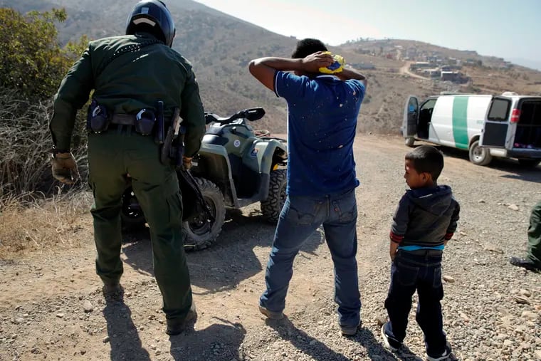 A Guatemalan father and son are detained by the Border Patrol after crossing the U.S.-Mexico border illegally in June 2018.