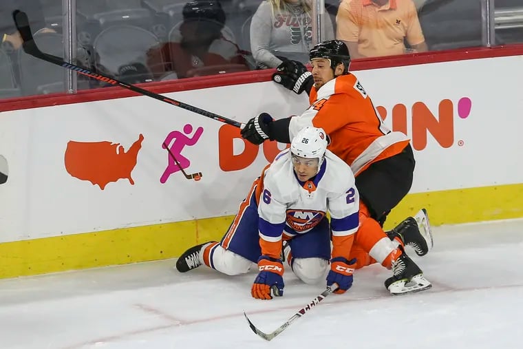 The Flyers' Chris Stewart (right) and the Islanders' Joshua Ho-Sang hit the ice during the first period at the Wells Fargo Center on Monday.