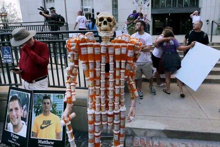 A skeleton of pill bottles stands with protesters outside a courthouse on Friday, Aug. 2, 2019, in Boston, where a judge was to hear arguments in Massachusetts' lawsuit against Purdue Pharma over its role in the national drug epidemic. Purdue executives discussed how they would combat an L.A. Times story online.  (AP Photo/Charles Krupa)