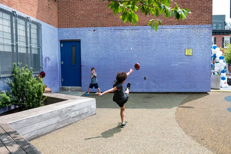 Children play with a football together at Chester A. Arthur Elementary school in Philadelphia in June. The school is now known as Marian Anderson Neighborhood Academy.