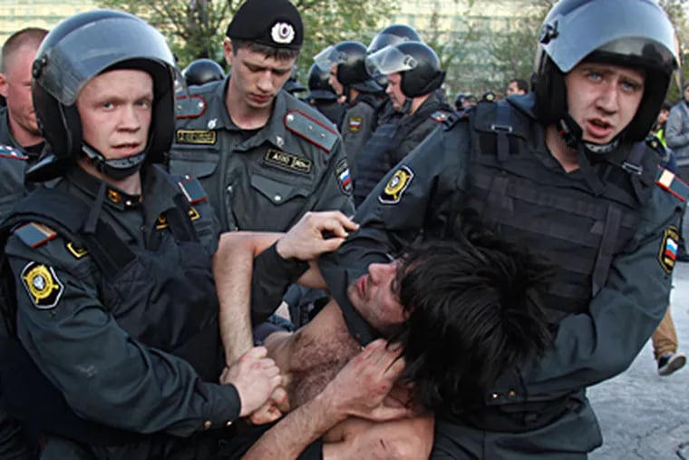 Riot police carry away a protester during an opposition rally in Moscow. More than 400 people were arrested and several demonstrators were injured Sunday. A dozen riot police also were hurt. MIKHAIL METZEL / Associated Press