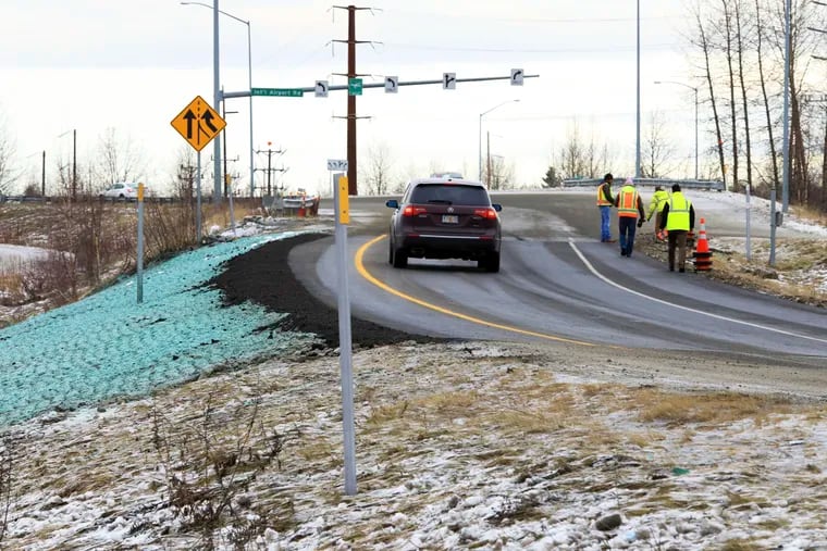 A car ascends a newly repaired off-ramp of Minnesota Drive on Wednesday, Dec. 5, 2018, in Anchorage, Alaska. A massive 7.0 earthquake and its aftershocks rocked buildings and buckled roads Nov. 30, including the road that's a route to Ted Stevens Anchorage International Airport. Alaska transportation officials made rebuilding the ramp a priority. It reopened Tuesday, Dec. 4, and a crew completed shoulder work Wednesday. (AP Photo/Dan Joling)